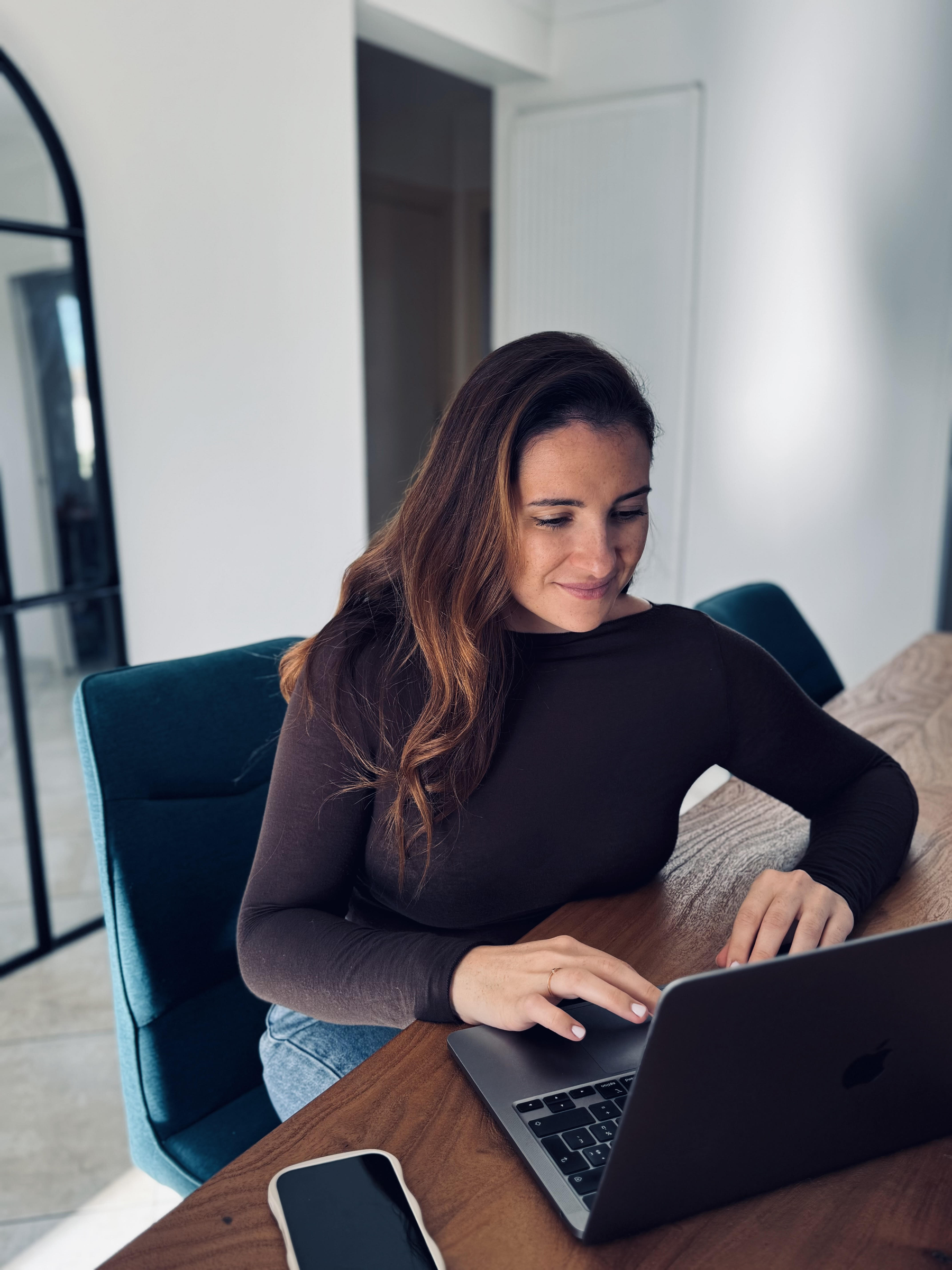 Mélanie Desmaries devant son laptop, community manager passionnée